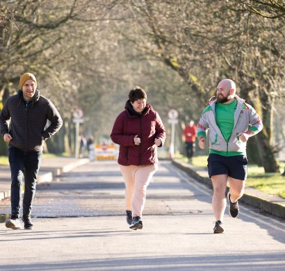 Three people running together in a park